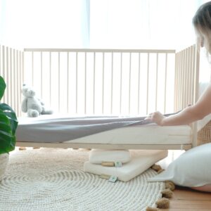 Heveya Junior natural Cot mattress displayed in a baby crib.