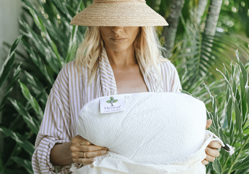 Woman showcasing a Heveya® Natural Organic Latex Pillow. Crafted with 100% natural latex, the pillow offers exceptional comfort and long-lasting durability.