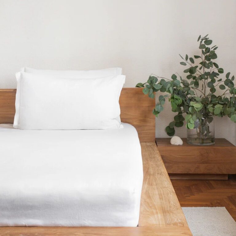 White Linen Fitted Sheet Set resting on a wooden bed